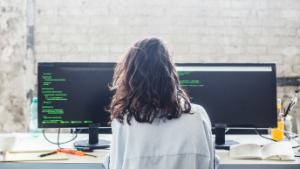 Persona sentada en una silla trabajando en su computadora